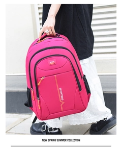Detail view of pink nylon sports backpack with side mesh pocket and zipper compartments