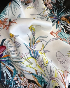 Close-up of silk-satin scarf fabric with paisley, floral, and bird print texture