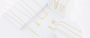 Close-up of 18K gold plated stainless steel necklaces with various minimalist pendants