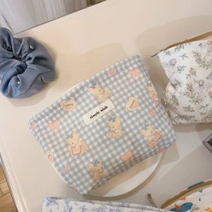 Detail of blue plaid canvas cosmetic bag with bear patterns and simple wish label