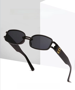Detail view of rectangular sunglasses featuring gold emblem on temple for street style