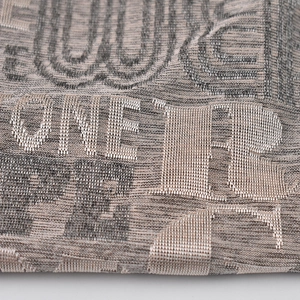 Makroaufnahme von grauem Jacquard-Strickstoff zeigt detaillierte Webstruktur und Fasern