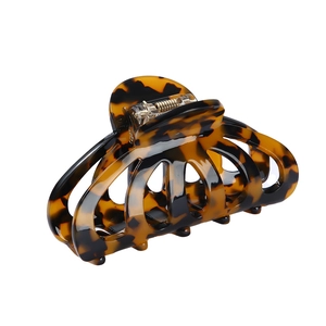 Pinza per capelli tartarugata marrone con design traforato su sfondo bianco