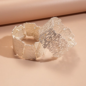 Matte silver wide open bangle featuring irregular hollow floral and textured patterns