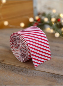 Close-up of red and white striped Christmas ribbon with silver glitter on wooden table