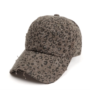 Detail of distressed leopard print baseball cap with frayed edges and vintage cotton texture