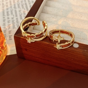 Détails de bagues dorées avec étoile à quatre branches sur un coffret en bois vintage