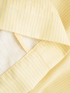 Macro view of light yellow striped fabric with precise stitching and cotton texture
