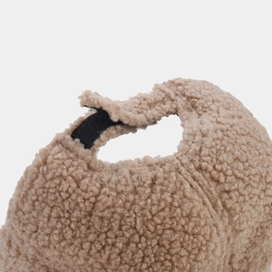 Detail of brown faux shearling baseball cap with adjustable black velcro strap at the back