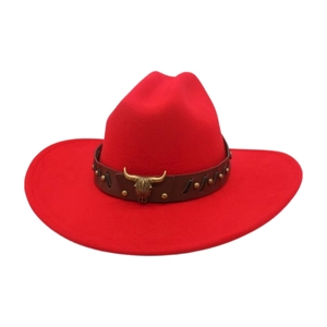 Detail of red felt cowboy hat featuring brown leather band and golden bull head emblem