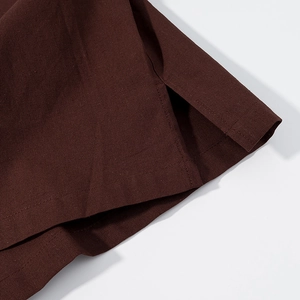 Vue macro de la texture en lin marron foncé et détail de fente latérale avec couture nette