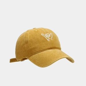 Detailed close-up of mustard yellow washed cotton baseball cap with shaka embroidery