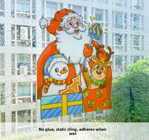 Detail of static Christmas window decals with Santa and Reindeer on wet glass surface
