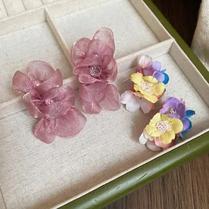 Elegant fabric flower earrings with chiffon petals and colorful beads in a jewelry box