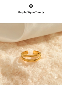 Detail of double-layer gold plated minimalist ring on elegant white silk background