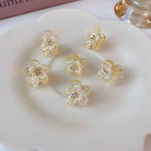 Close-up of small floral hair claws with rhinestones on a decorative ceramic plate
