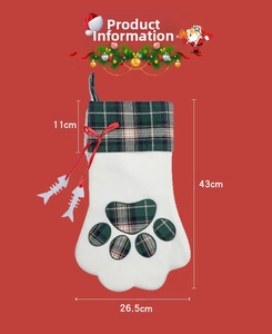 Détail d'une chaussette de Noël en patte de chien avec motif écossais vert et breloques