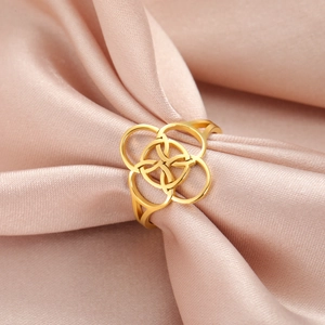 Polished gold five-link interlocking ring on pink silk background for a minimalist style