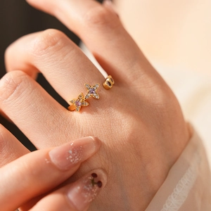 Detailed view of an adjustable gold star ring featuring purple gems and clear rhinestones