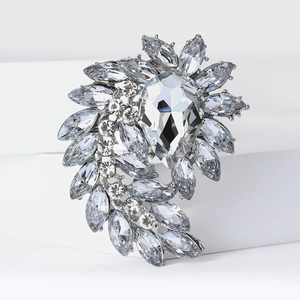 Macro detail of silver floral brooch featuring mixed-cut rhinestones and pear-shaped crystals
