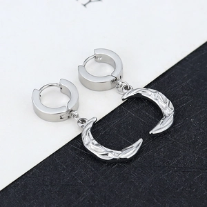 Macro shot of silver crescent moon hoop earrings with a hammered metal texture finish