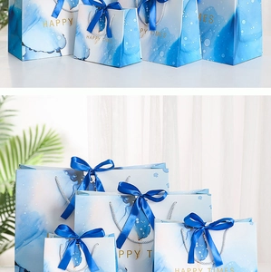 Various sizes of marble blue watercolor gift bags with dark blue ribbon handles
