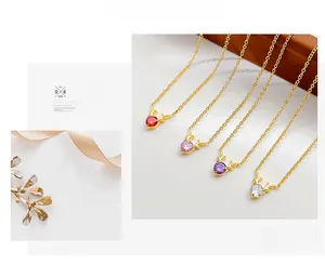 Detail view of dainty gold deer horn necklaces featuring red pink purple and white gems