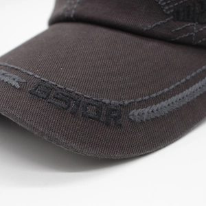 Macro shot of G-STAR logo embroidery and detailed stitching on dark canvas baseball cap brim