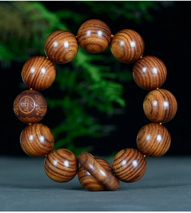 Vue détaillée de 12 perles en bois de Dalbergia avec gravure et grain naturel