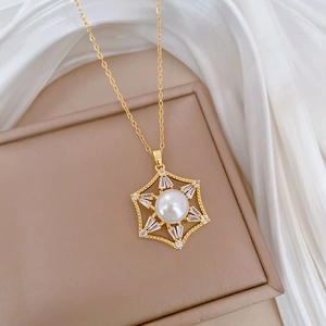Detail of gold titanium hexagon necklace with white pearl and sparkling crystals