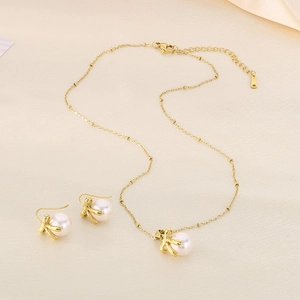 Detail view of pearl bow pendant necklace and matching gold hook earrings set