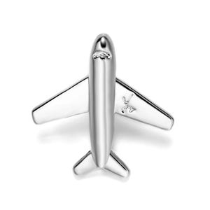 Macro detail of silver airplane brooch featuring polished finish and engraved logo