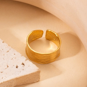 Macro shot of gold adjustable ring featuring a unique irregular textured surface design