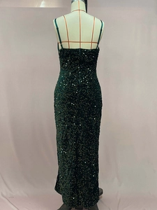 Détail du tissu à paillettes vert foncé sur la robe de soirée avec reflets scintillants