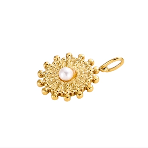 Detail of vintage gold sunflower pendant with center pearl inlay and sunburst design