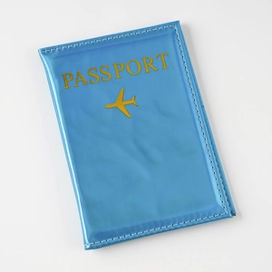 Detailed shot of sky blue laser PU leather passport holder with golden plane icon