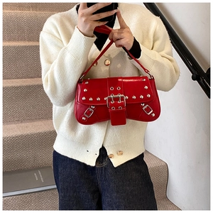 Y2K punk style red glossy leather shoulder bag with silver studs on a female model