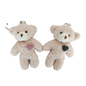 Pair of beige plush teddy bear keychains with pink and grey heart accents for bags