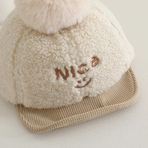 Casquette bébé en polaire sherpa crème avec pompon doux et broderie souriante
