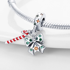 Macro detail of Christmas candy cane charm with red white enamel and green zirconia