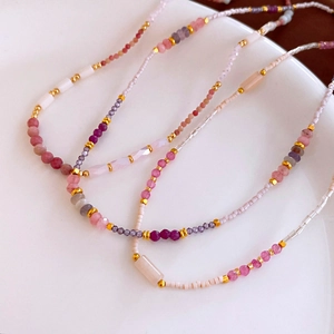 Detailed macro view of colorful natural stone beads and gold accents on luxury necklaces