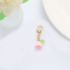 Detailed close-up of pink flower keychain with golden lobster clasp and green leaf