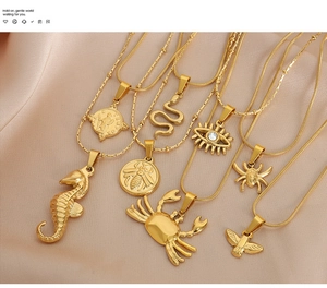 Detailed view of gold-plated necklaces featuring sea horse, crab, and snake charms on satin