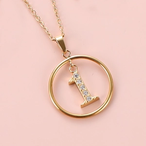 Macro shot of gold stainless steel necklace with sparkling zircon number 1 pendant