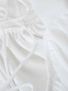 Close-up of white mesh fabric detail with delicate drawstring and pleated hem design