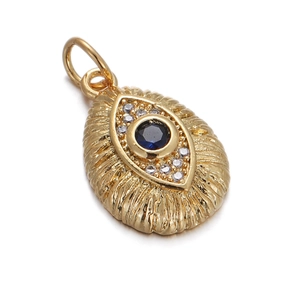 Detailed shot of golden oval pendant featuring a deep blue gemstone and clear zircon border