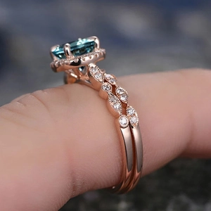 Macro shot of emerald cut teal gemstone bridal ring set in elegant rose gold finish