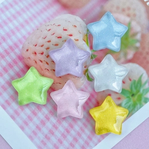 Glittering colorful resin stars for DIY accessories on a cute strawberry background