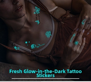 Close-up of luminous blue butterfly and rose tattoo stickers glowing in the dark
