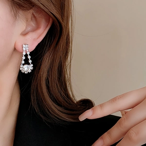 Close-up of elegant geometric water drop tassel earrings with silver crystal setting